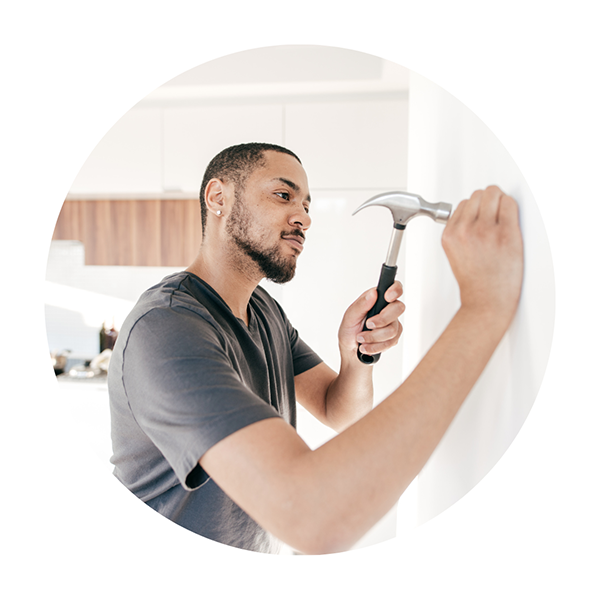 man hammering nail into wall