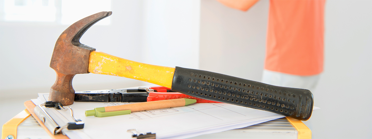 hammer on clipboard with pens