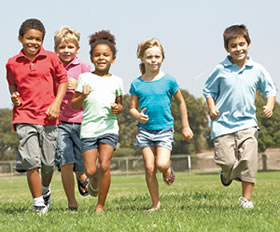 photo of children running on a park lawn